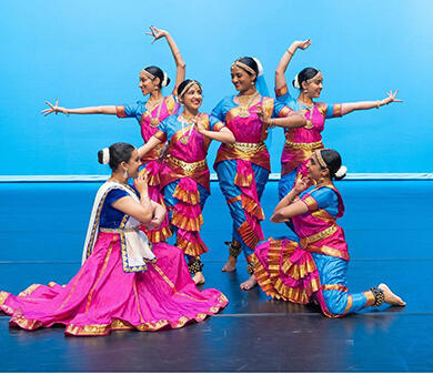 The Stanford Noopur dance troupe poses onstage at a competition