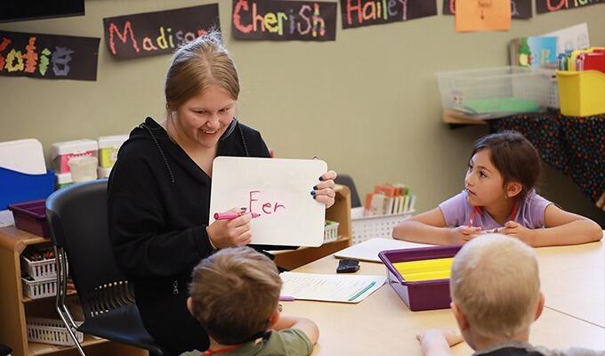 Female student teacher reading to children