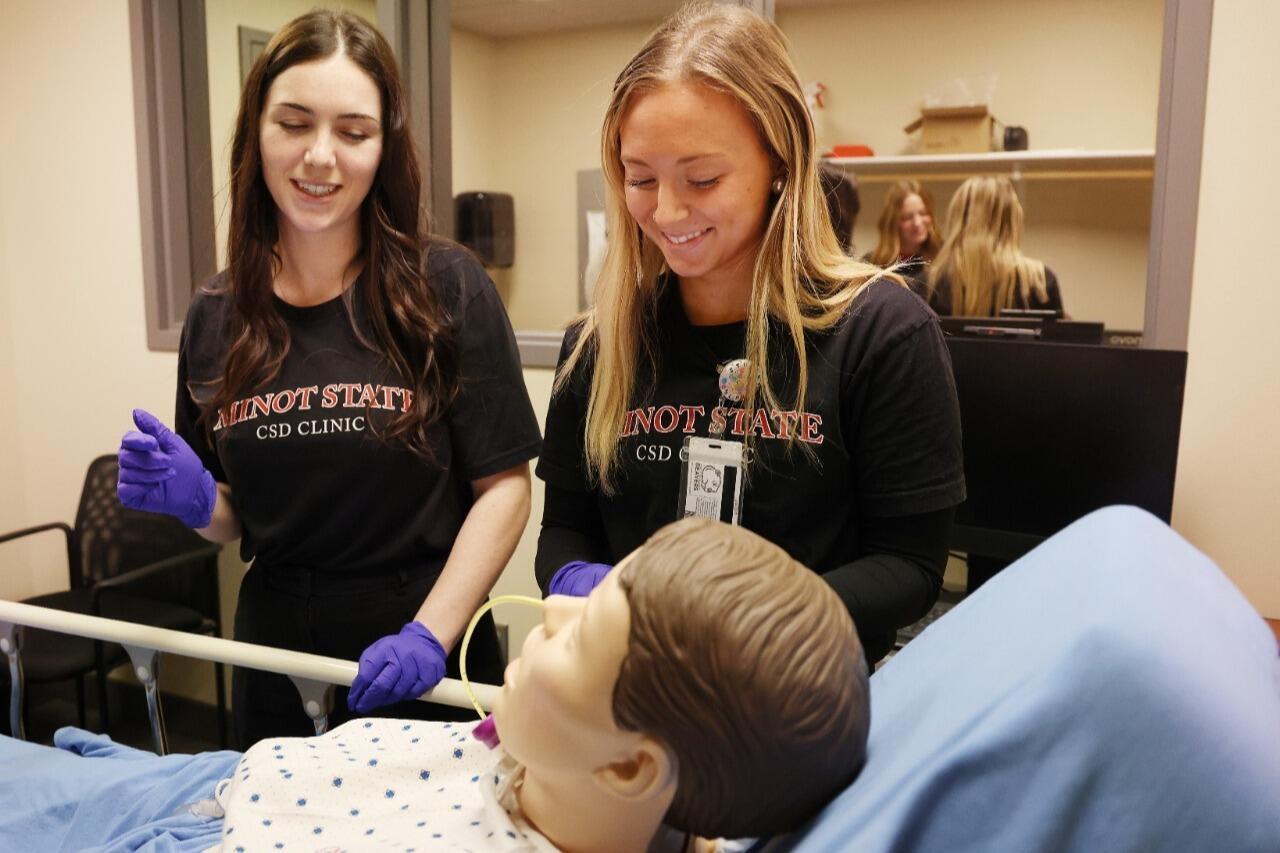Female student working with a child in the communication disorders clinic