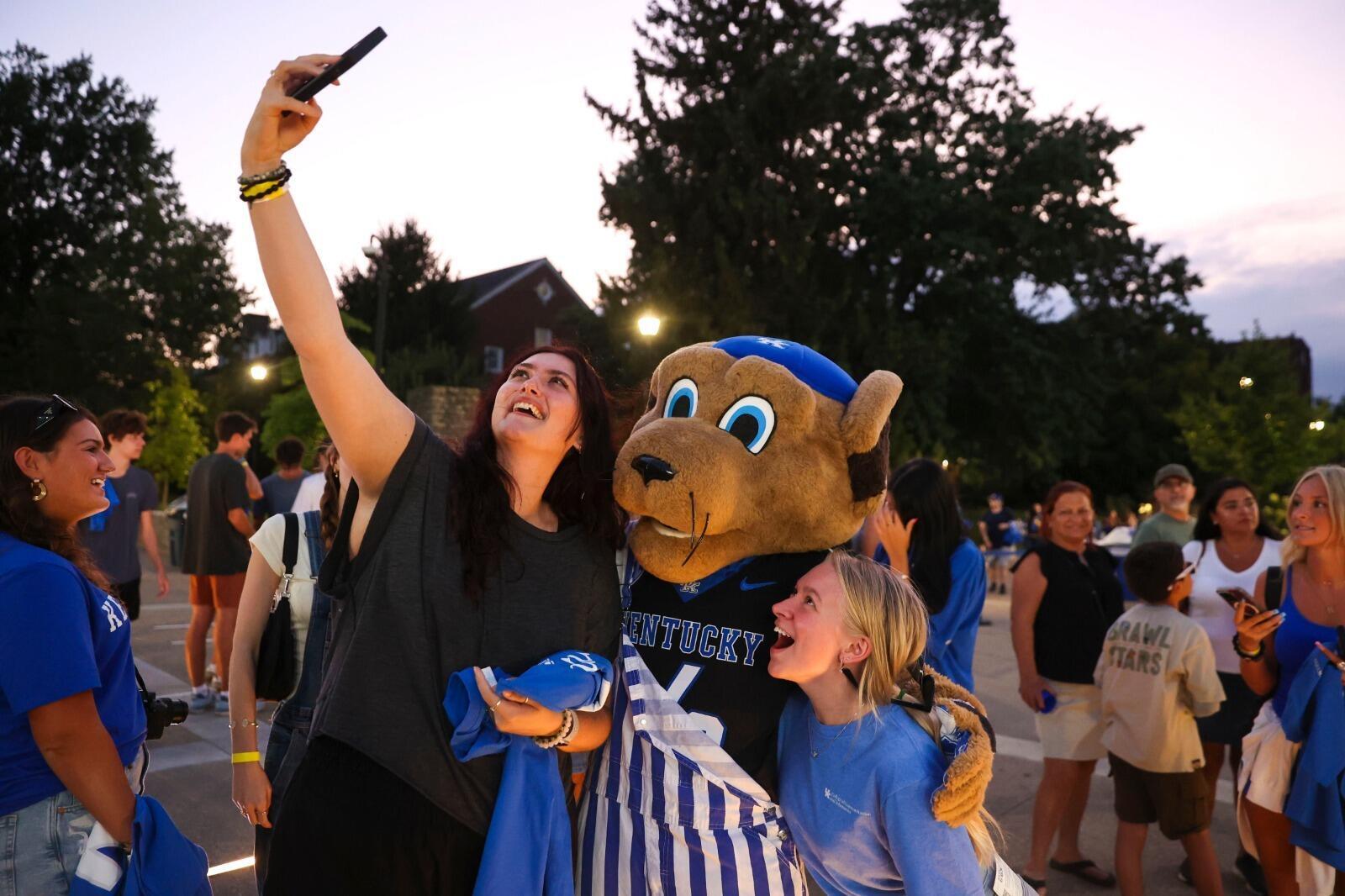 Students taking a selfie with the Wildcat mascot