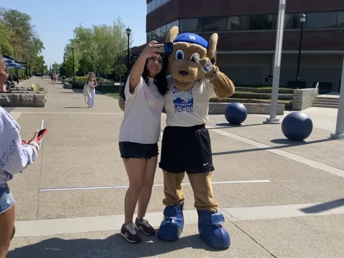 UK Staff Members posing in front of the large blue C A T S letters